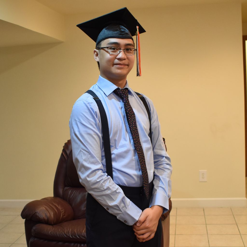 Portrait photo of John Burch wearing a graduation cap and formal clothing